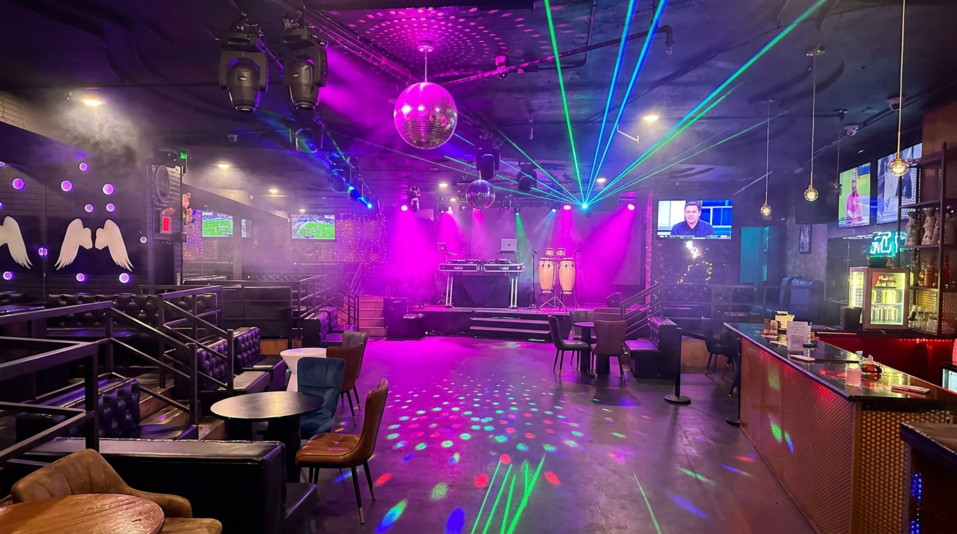 DJ booth with turntables and congas at The Zone NYC under magenta lights and lasers — How to Learn Salsa in NYC as a Total Beginner